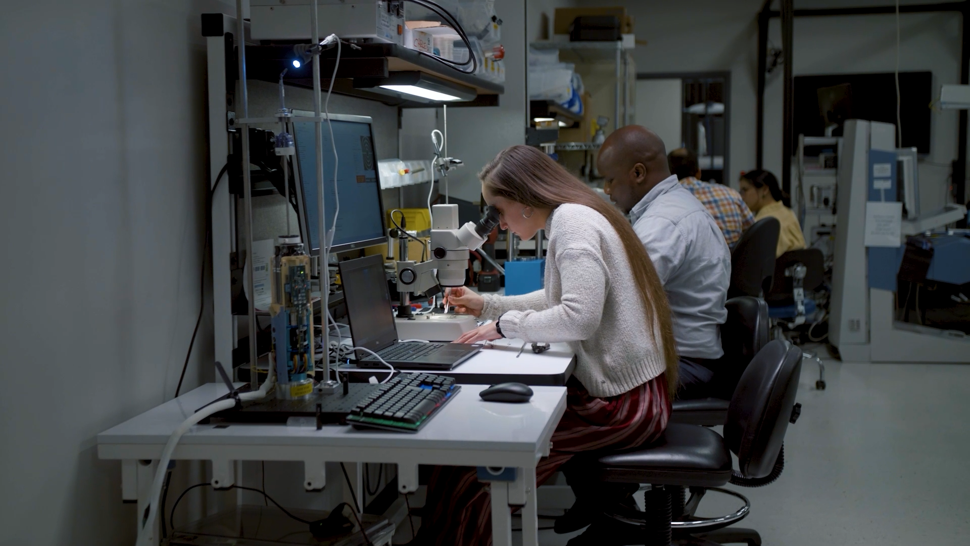 A woman looking through a microscope 